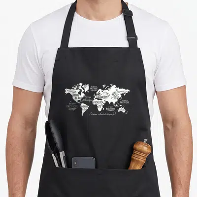 Tablier de cuisine noir avec carte du monde stylisée en blanc intégrant les noms des continents et des océans en lettres cursives.
