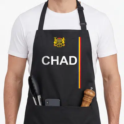 Tablier de cuisine noir avec CHAD, armoiries dorées et bandes verticales bleue jaune rouge sur la droite.