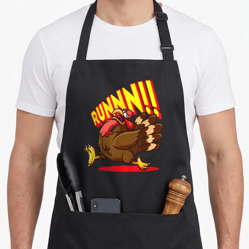 Tablier de cuisine noir avec une dinde cartoon fuyante et le mot RUNNN. en lettres jaunes et rouges.