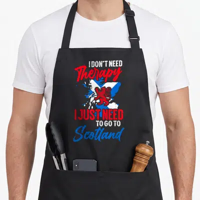 Tablier de cuisine noir avec le drapeau de l'Écosse et un lion rouge stylisé au centre du motif imprimé.