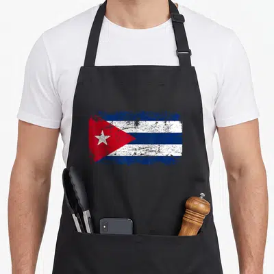Tablier de cuisine noir avec le drapeau de Cuba en style vieilli et textures écaillées.