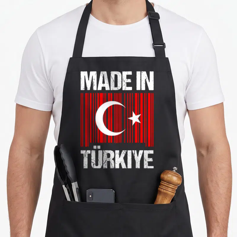 Tablier de cuisine noir avec inscription « Made in Türkiye » et drapeau turc stylisé en barcode rouge.