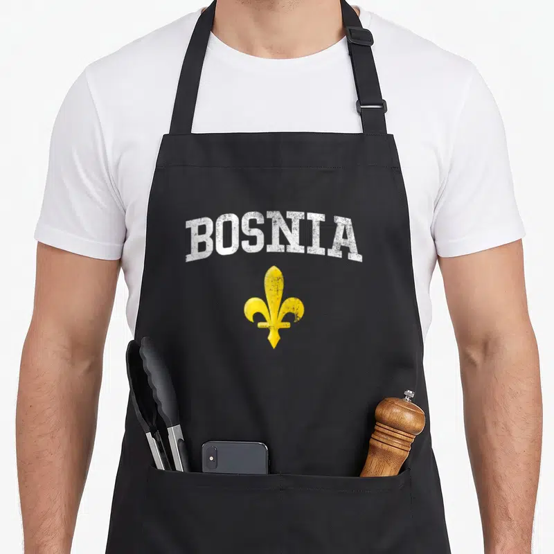 Tablier de cuisine noir avec inscription BOSNIA et symbole Zlatni Ljiljan jaune sur fond uni.