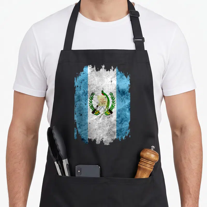Tablier de cuisine noir avec drapeau du Guatemala stylisé et quetzal au centre.