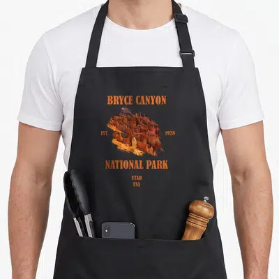Tablier de cuisine noir avec illustration orange du Bryce Canyon National Park et texte Est 1928 Utah USA