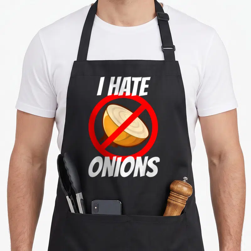 Tablier de cuisine noir avec inscription I HATE ONIONS et illustration d'un oignon barré en rouge.