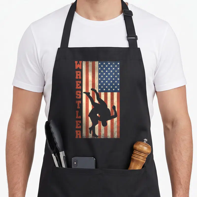 Tablier de cuisine noir avec drapeau américain vintage et silhouette de lutteur verticalement aligné.