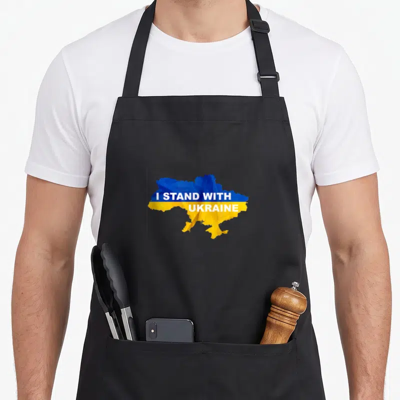 Tablier de cuisine noir avec carte Ukraine bleue et jaune portant le texte I Stand With Ukraine au centre.