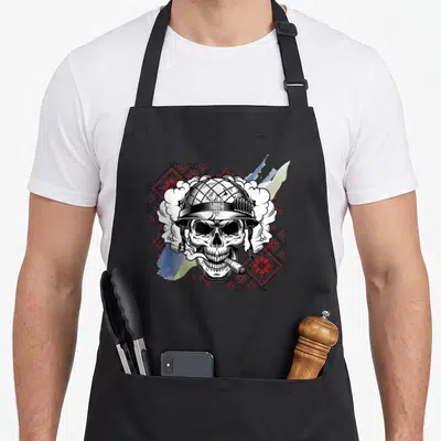 Tablier de cuisine noir avec crâne casque trident et motifs ukrainiens rouges et bleus.