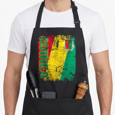 Tablier de cuisine noir avec le drapeau de la Guinée et l'inscription GUINEA en vertical style dégradé.