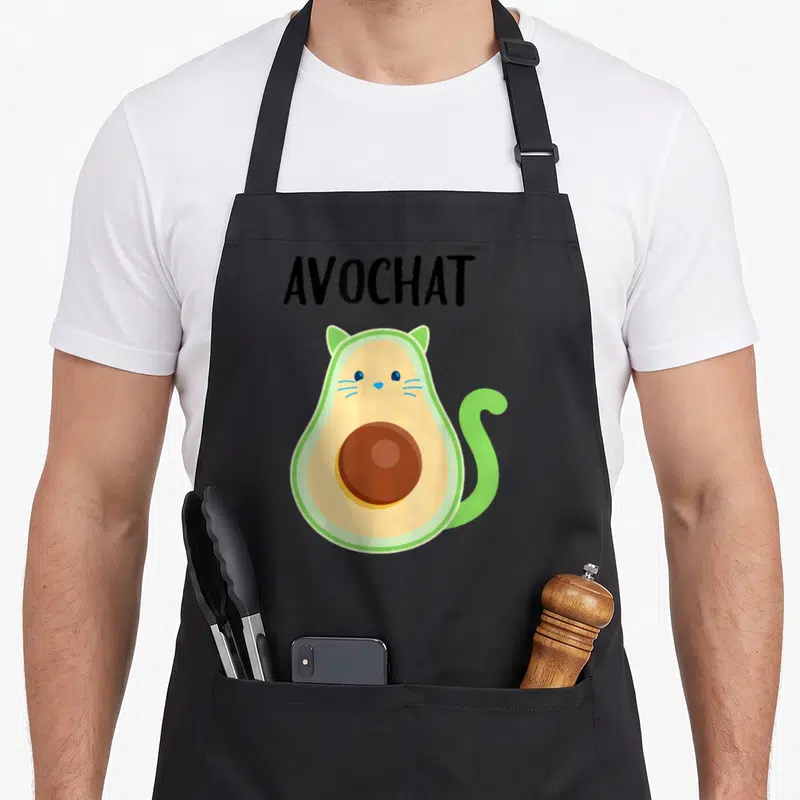 Tablier de cuisine noir avec illustration d'un avocat chat vert et jaune portant le mot Avochat en lettres noires.