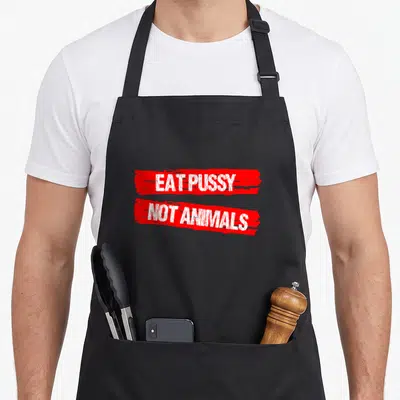 Tablier de cuisine noir avec inscription blanche Eat Pussy Not Animals sur bandes rouges.