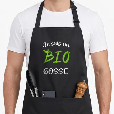 Tablier de cuisine noir avec inscription Je suis un « Bio » Gosse en blanc et vert avec une feuille stylisée sur la lettre B.