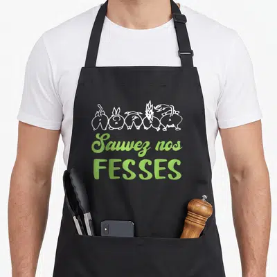 Tablier de cuisine noir avec texte vert « Sauvez nos fesses » et silhouettes animales blanches en haut.