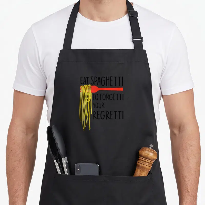 Tablier de cuisine noir avec une fourchette rouge enroulée de spaghettis jaunes et du texte noir.