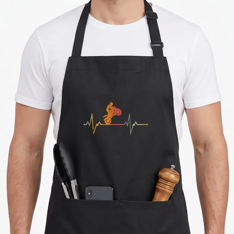 Tablier de cuisine noir avec un motocycliste orange sur une ligne de battement de cœur multicolore.