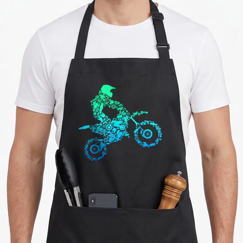 Tablier de cuisine noir avec silhouette de pilote de moto motocross composée de pièces mécaniques en dégradé de couleurs.