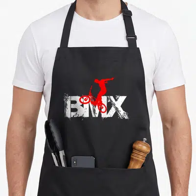 Tablier de cuisine noir avec silhouette rouge cycliste BMX et texte blanc texturé.