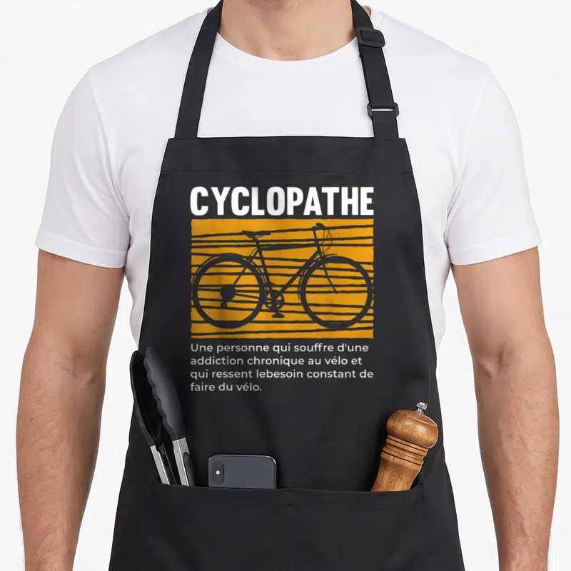 Tablier de cuisine noir avec illustration d'un vélo gris sur fond orange et le mot Cyclopathe en lettres blanches.