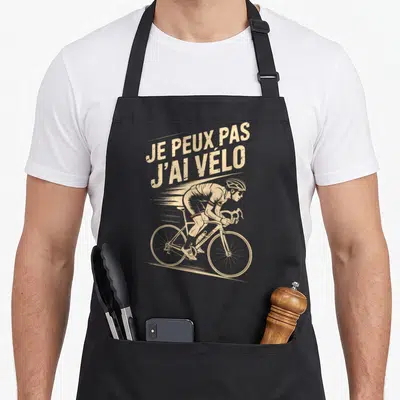 Tablier de cuisine noir avec illustration vintage d'un cycliste penché sur sa roue et le texte Je peux pas j'ai vélo en haut.