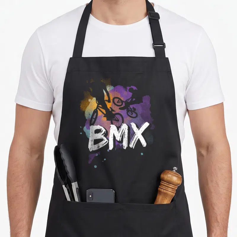 Tablier de cuisine noir avec une illustration colorée représentant un cycliste BMX et le mot BMX en blanc.