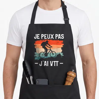 Tablier de cuisine noir avec silhouette cycliste VTT sur fond dégradé orange et bleu et texte blanc Je peux pas j'ai VTT.