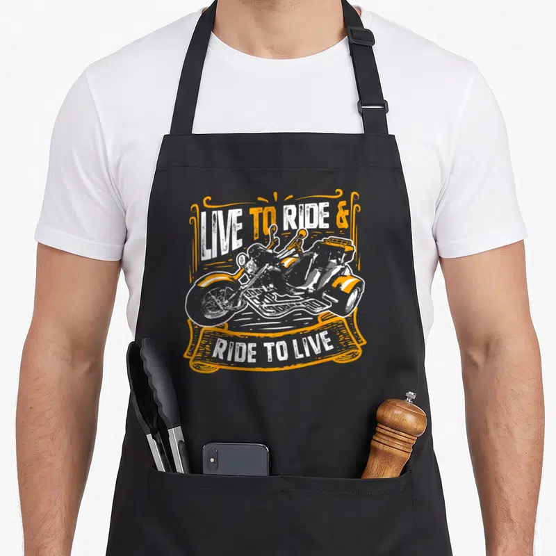 Tablier de cuisine noir avec illustration trike vintage et texte Live to ride Ride to live en orange et blanc.