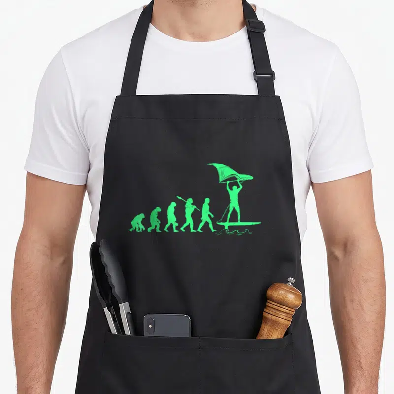 Tablier de cuisine noir avec illustration verte représentant l'évolution humaine vers le wing foil.