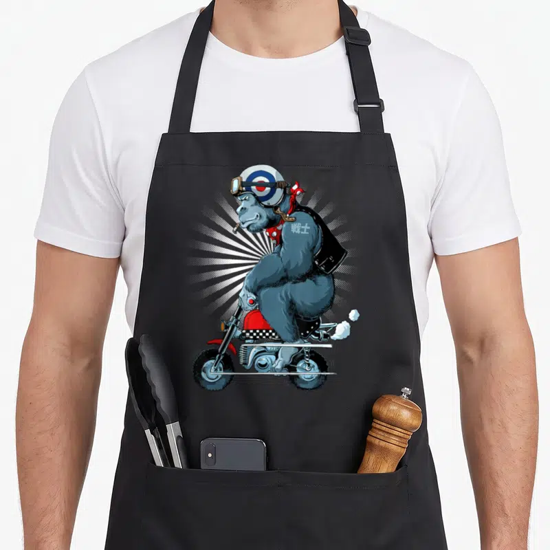 Tablier de cuisine noir avec illustration d'un gorille en casque cible montant une moto rouge vintage.