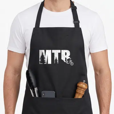 Tablier de cuisine noir avec inscription MTB blanche intégrant des arbres et un cycliste sur sentier.