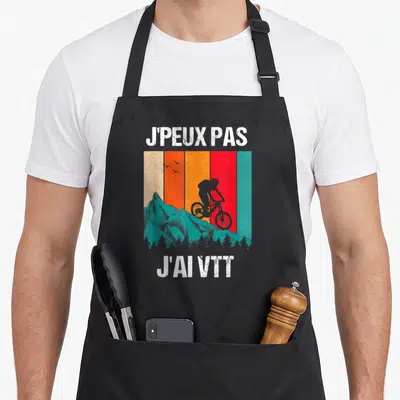 Tablier de cuisine noir avec illustration vintage d'un cycliste sur montagne et texte blanc J'peux pas j'ai VTT