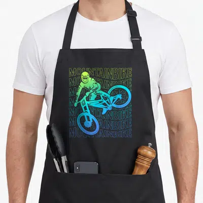 Tablier de cuisine noir avec illustration cycliste et texte MOUNTAINBIKE en dégradé vert et bleu.