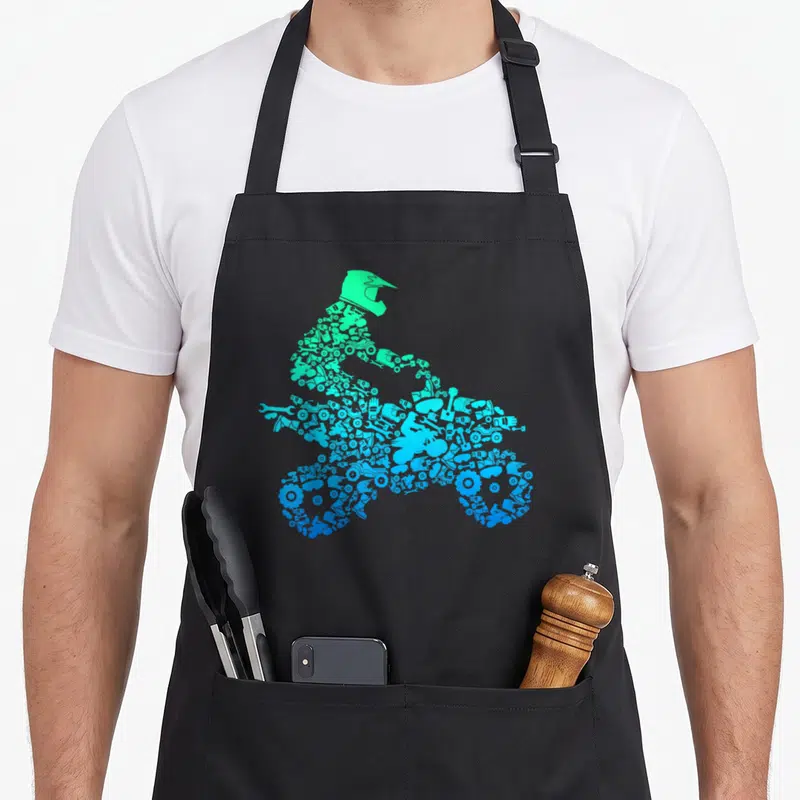 Tablier de cuisine noir avec silhouette motatd quad formée d'outils mécaniques en dégradé bleu et vert.