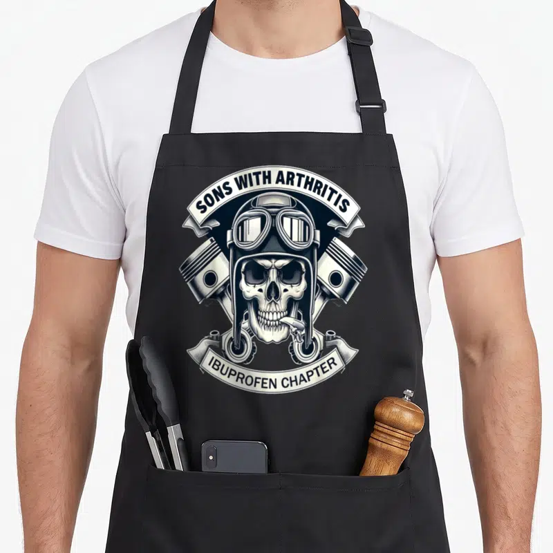 Tablier de cuisine noir avec un crâne biker casqué, des pistons croisés et les textes Sons With Arthritis et Ibuprofen Chapter.