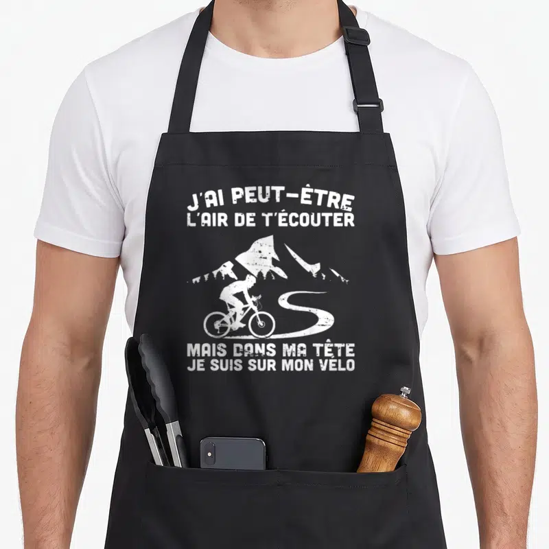 Tablier de cuisine noir avec silhouette de cycliste et texte blanc J'ai peut-être l'air de t'écouter mais dans ma tête je suis sur mon vélo