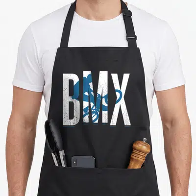 Tablier de cuisine noir avec l'inscription BMX blanche et une silhouette bleue d'un cycliste en plein saut acrobatique.