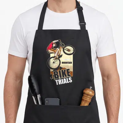 Tablier de cuisine noir avec illustration d'un cycliste effectuant un saut en VTT Trial et le texte BIKE TRIALS.