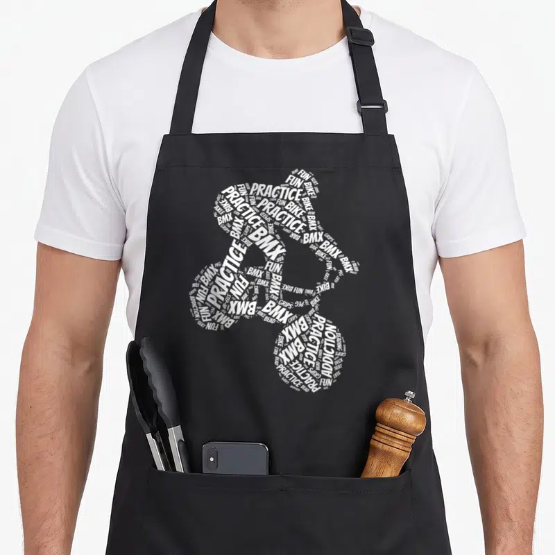 Tablier de cuisine noir avec une silhouette de vélo formée par des mots blancs comme BMX et PRACTICE.