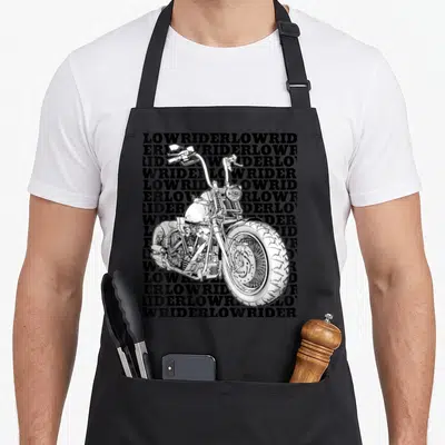Tablier de cuisine noir avec illustration moto bobber et texte Lowrider en arrière-plan typographique.