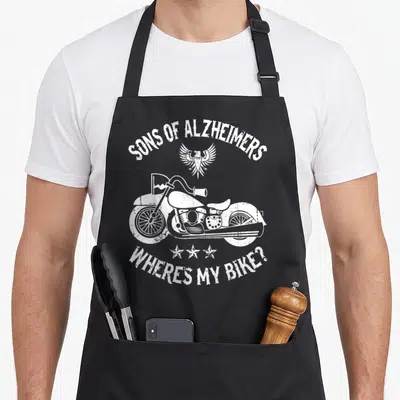 Tablier de cuisine noir avec illustration blanche moto vintage, aigle aux ailes déployées et texte Sons of Alzheimers où est mon vélo.