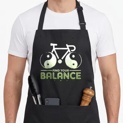 Tablier de cuisine noir avec illustration vélo aux roues yin yang et texte vert Find Your Balance