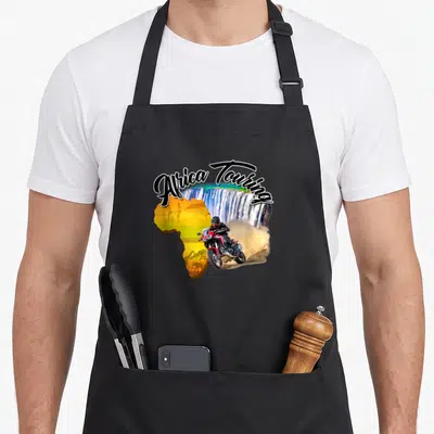 Tablier de cuisine noir avec illustration d'une moto rouge traversant une carte d'Afrique colorée devant un grand waterfall.