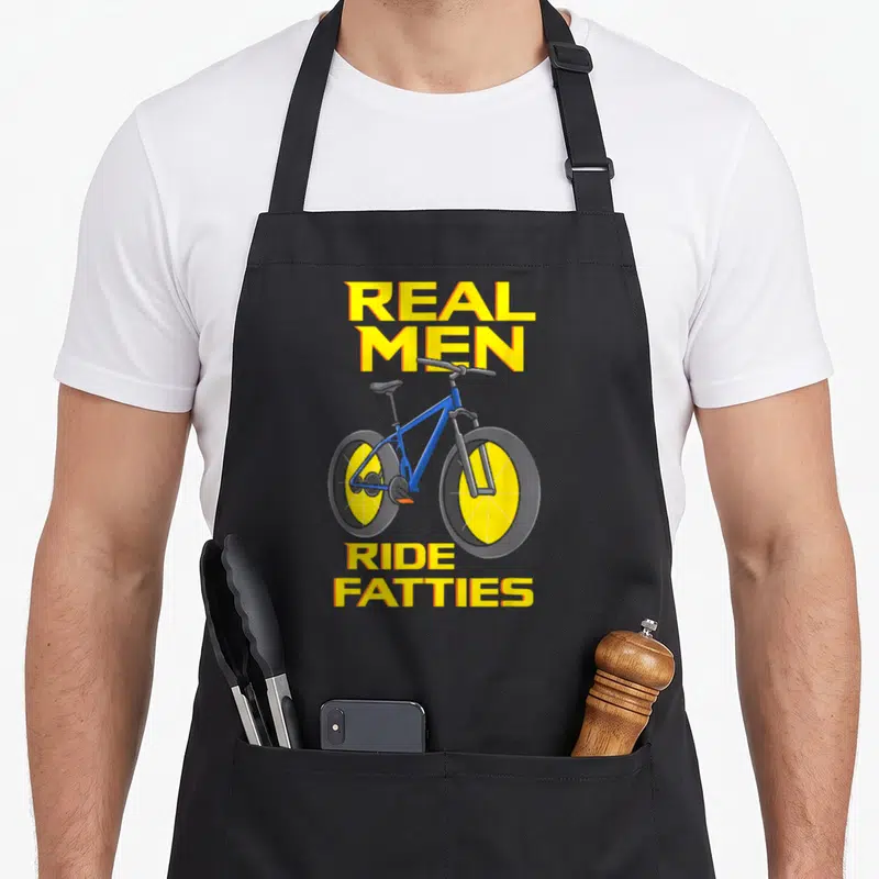 Tablier de cuisine noir avec illustration de fatbike bleu et texte jaune Real Men Ride Fatties.