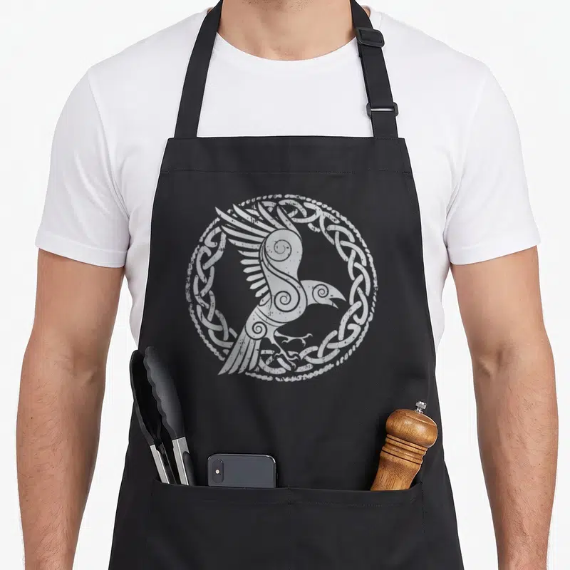 Tablier de cuisine noir avec oiseau stylisé en cercle d'entrelacs celtiques et motifs spirales gris clair sur fond uni.