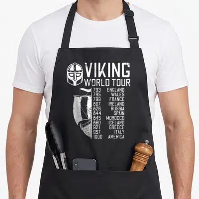 Tablier de cuisine noir avec illustration blanche d'un casque viking, d'une drakkar et une liste de pays visités avec leurs années respectives.