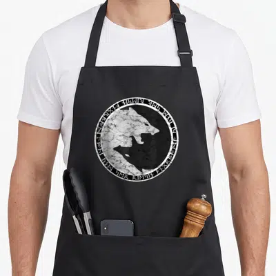 Tablier de cuisine noir avec un loup Fenrir et des runes nordiques dans un cercle blanc texturé.