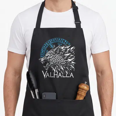 Tablier de cuisine noir avec tête de loup blanc, runes circulaires bleues et inscription Valhalla en bas.