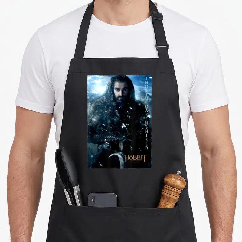 Tablier de cuisine noir avec l'image de Thorin Oakenshield tenant une arme dans un décor hivernal bleu et blanc.