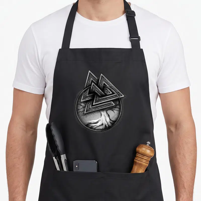 Tablier de cuisine noir avec un arbre de vie et un knot valkyrie gravés en noir et blanc.