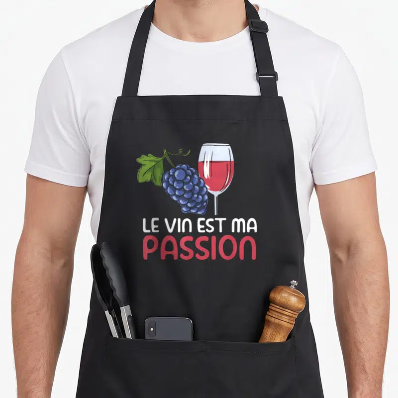 Tablier de cuisine noir avec illustration de grappe de raisin, verre de vin rouge et texte Le Vin Est Ma Passion.